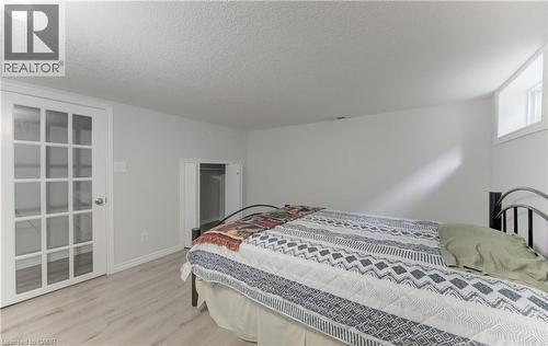 Room featuring wood-finish flooring, white walls, and a window for natural light - 104 Mausser Avenue, Kitchener, ON 