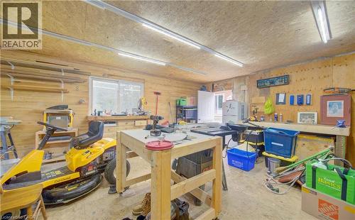 Workshop space featuring wood lined walls, built-in shelving, a large window, and overhead strip lighting - 104 Mausser Avenue, Kitchener, ON 