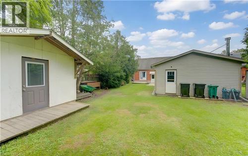 Expansive grass lawn with two detached outbuildings featuring exterior doors - 104 Mausser Avenue, Kitchener, ON 