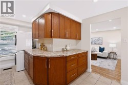 Kitchenette featuring wood cabinetry, stone-finish countertops, tile backsplash, and recessed lighting - 