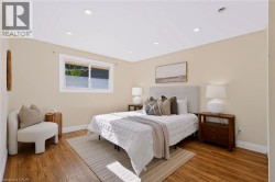 Recessed lighting, wood-finish flooring, and a single window with white trim - 