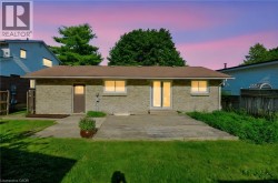 Brick exterior featuring a brown shingle roof, a glass-paneled entry door, and a sliding glass patio door - 