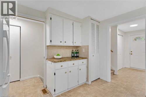 White cabinetry with gold-tone hardware, tile backsplash, and composite countertop - 7 Underhill Crescent, Kitchener, ON 