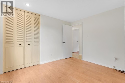 Wood-finish flooring throughout, paired with a louvered bifold closet door - 7 Underhill Crescent, Kitchener, ON 
