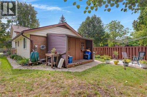 Expansive backyard featuring a manicured lawn, a privacy fence, and a paved patio area - 7 Underhill Crescent, Kitchener, ON 