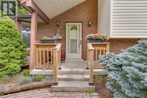 Brick exterior with light-colored siding accents, concrete steps, and wooden porch railings - 7 Underhill Crescent, Kitchener, ON 