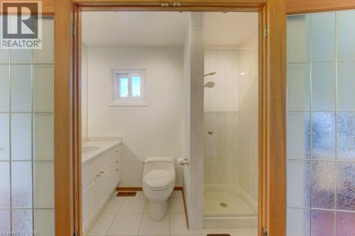 Bathroom with tile flooring, white vanity with dual sinks, and a glass-enclosed shower - 238 Mcgarry Drive, Kitchener, ON 