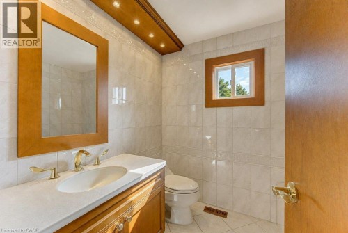 Wood-finish vanity with an integrated sink and gold-tone fixtures - 238 Mcgarry Drive, Kitchener, ON 