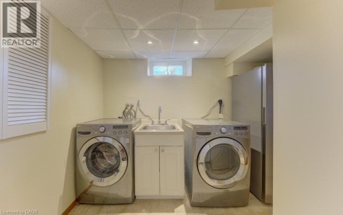 Utility area featuring a built-in sink with a base cabinet, recessed lighting, and a louvered panel - 238 Mcgarry Drive, Kitchener, ON 