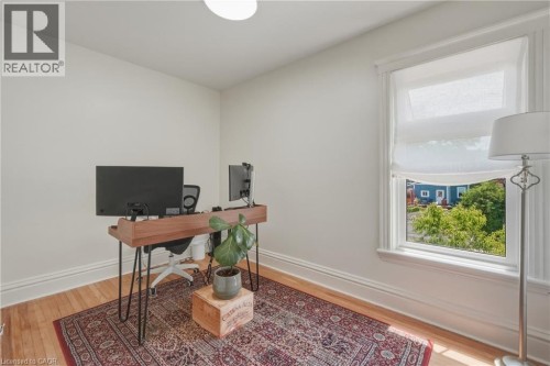 Hardwood flooring, white wall paint, window with trim, white window shades, and a ceiling-mounted light fixture - 42 Nightingale Street, Hamilton, ON 