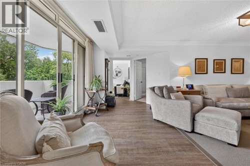 Spacious living area featuring wood-finish flooring extending to a private balcony - 1237 North Shore Boulevard Unit# 405, Burlington, ON 