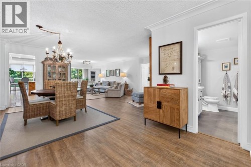Open-concept interior featuring wood-finish flooring, recessed lighting, crown molding, and a chandelier - 1237 North Shore Boulevard Unit# 405, Burlington, ON 