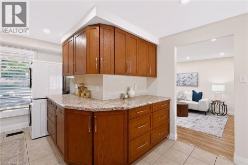 Kitchenette featuring wood cabinetry, stone-finish countertops, tile backsplash, and recessed lighting - 95 Underhill Crescent, Kitchener, ON 