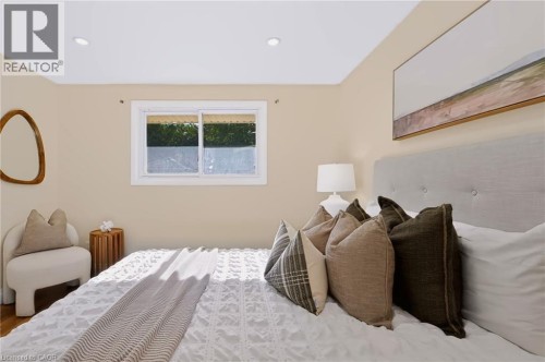 Recessed ceiling lighting, light neutral wall paint, wood-finish flooring, sliding window with white trim, upholstered headboard - 95 Underhill Crescent, Kitchener, ON 