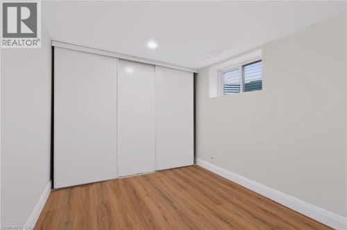 Recessed lighting, wood-finish flooring, white sliding closet doors, and white window trim - 95 Underhill Crescent, Kitchener, ON 