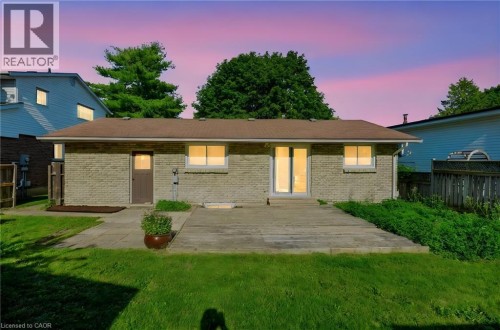Brick exterior featuring a brown shingle roof, a glass-paneled entry door, and a sliding glass patio door - 95 Underhill Crescent, Kitchener, ON 