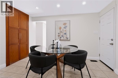 Recessed lighting illuminates the space, featuring tile flooring and a built-in wood-finish cabinet with paneling - 95 Underhill Crescent, Kitchener, ON 