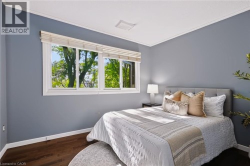 Expansive multi-pane window with natural wood blinds, dark wood-finish flooring, and crown molding - 121 University Avenue E Unit# 102, Waterloo, ON 