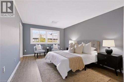 Wood-finish flooring, white trim, window, and wall-mounted lighting - 121 University Avenue E Unit# 102, Waterloo, ON 