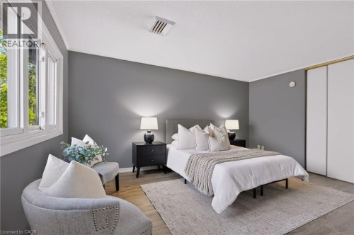 Wood-finish flooring, white trim, sliding closet doors, and multiple windows - 121 University Avenue E Unit# 102, Waterloo, ON 