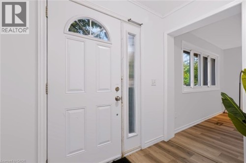 White paneled entry door with an arched transom, a full-length sidelight, and wood-finish flooring - 121 University Avenue E Unit# 102, Waterloo, ON 