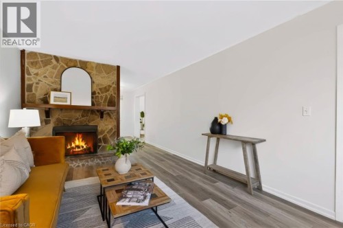 Stone accent wall with a built-in fireplace, mantel, and hearth - 121 University Avenue E Unit# 102, Waterloo, ON 