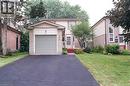 Two-story exterior featuring brick and siding construction, attached garage, paved driveway, and established front yard landscaping - 543 Drummerhill Crescent, Waterloo, ON 