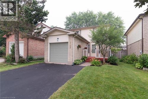 Brick and siding exterior with an attached garage, paved driveway, and established front landscaping - 543 Drummerhill Crescent, Waterloo, ON 