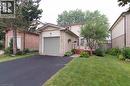 Brick and siding exterior with an attached garage, paved driveway, and established front landscaping - 543 Drummerhill Crescent, Waterloo, ON 