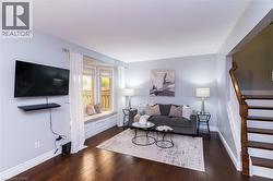 Dark wood-finish flooring, a built-in window seat, and a wall-mounted entertainment shelf - 