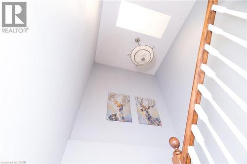 Skylight, flush mount ceiling fixture, and wood railing with white balusters - 543 Drummerhill Crescent, Waterloo, ON 