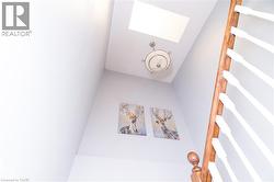 Skylight, flush mount ceiling fixture, and wood railing with white balusters - 