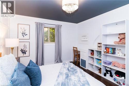 Ceiling-mounted chandelier, crown molding, built-in shelving, desk with integrated storage, and window with natural light - 543 Drummerhill Crescent, Waterloo, ON 