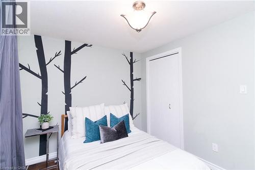 Recessed ceiling light fixture, accent wall with decorative tree decals, bifold closet door, light-colored wall paint - 543 Drummerhill Crescent, Waterloo, ON 