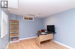 Recessed window with white trim, track lighting fixture, light wood-finish flooring, and white baseboards - 