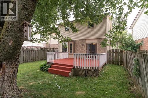 Expansive backyard with a wood deck, wood privacy fencing, and mature trees - 543 Drummerhill Crescent, Waterloo, ON 