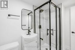 Modern vanity and glass-enclosed shower - 