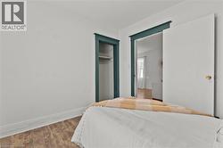 Wood-finish flooring, white walls, and a built-in closet with shelving - 