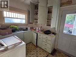 Kitchen featuring original cabinetry, transom window, and patterned resilient flooring - 