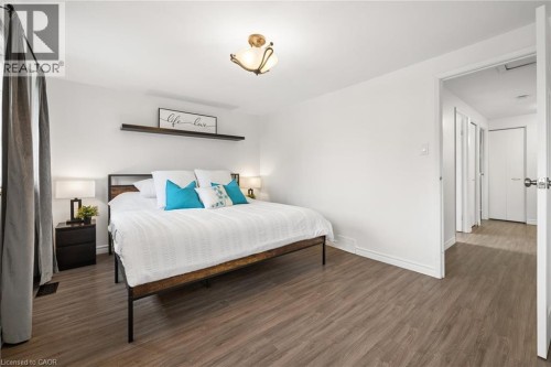Wood-finish flooring throughout, bright white walls, and a recessed ceiling light fixture - 76 Cluthe Crescent, Kitchener, ON 