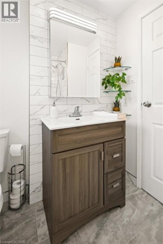 Vanity with wood-look cabinetry and a white countertop - 76 Cluthe Crescent, Kitchener, ON 