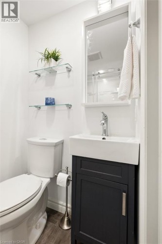 White vanity with a rectangular vessel sink, chrome faucet, and dark cabinet - 76 Cluthe Crescent, Kitchener, ON 