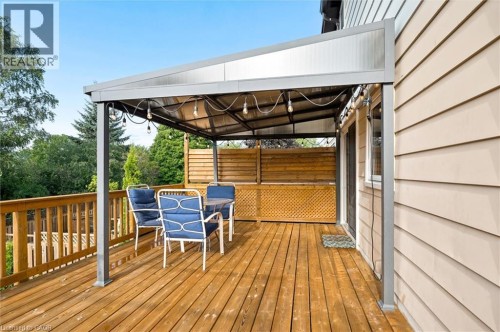Expansive wooden deck with a covered pergola, featuring a privacy screen and direct exterior access - 76 Cluthe Crescent, Kitchener, ON 
