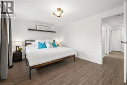 Wood-finish flooring throughout, bright white walls, and a recessed ceiling light fixture - 