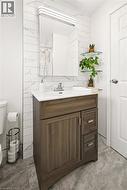 Vanity with wood-look cabinetry and a white countertop - 