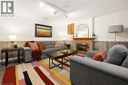 Brick-clad fireplace with a brass-toned insert, wood mantel, and track lighting - 