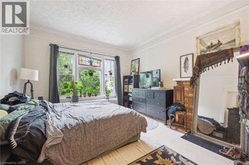 Hardwood flooring, painted white walls, crown molding, double window, and a brick fireplace - 143 David Street, Kitchener, ON 