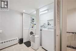 Laundry area with patterned flooring, louvered bi-fold doors, and recessed lighting - 