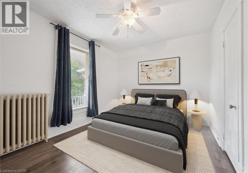 Hardwood-style flooring, white walls, ceiling fan with integrated lighting, and a paneled door - 143 David Street, Kitchener, ON 