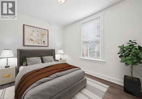 White painted walls, wood-finish flooring, single window with blinds, and recessed lighting - 143 David Street, Kitchener, ON 